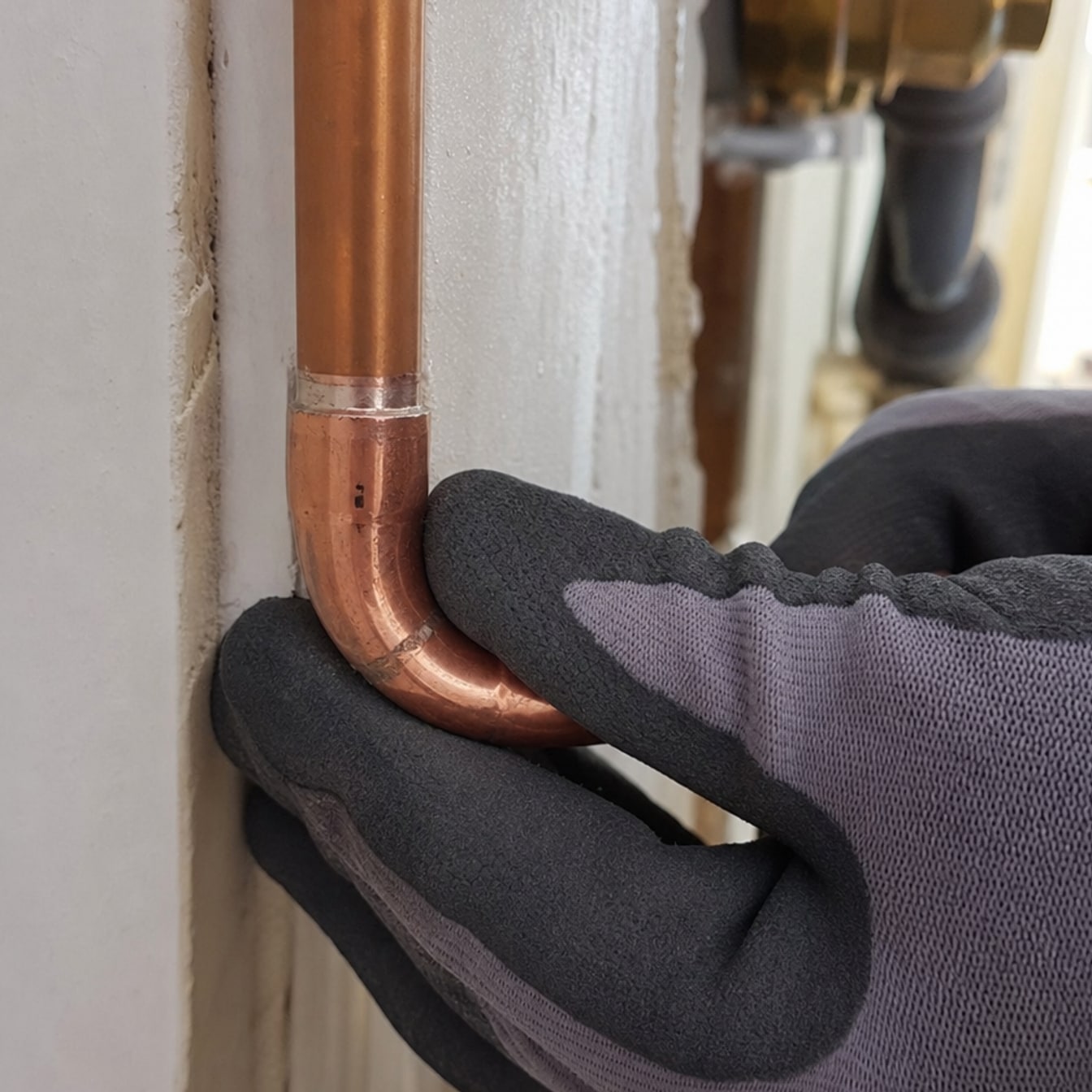 mains gantées contrôlant tuyauterie en cuivre